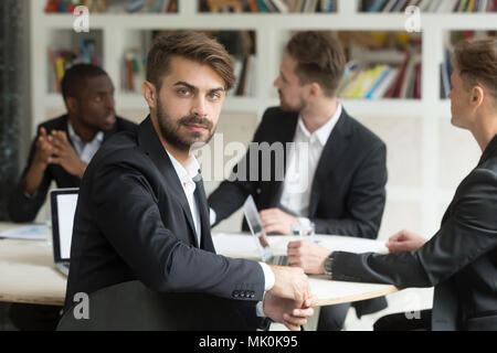 Male worker looking at camera at company business meeting Stock Photo