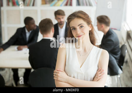 Attractive female leader posing in front of colleagues Stock Photo