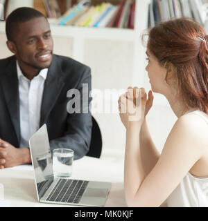 Male african american and female caucasian negotiating at briefi Stock Photo