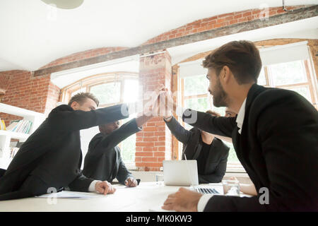 Colleagues giving high five for successful business deal Stock Photo