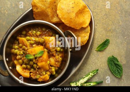 Homemade Aloo Mutter / Alu Matar  / Indian Peas potato curry served with Masala Puri Stock Photo