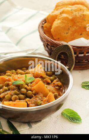 Alu Matar ( Aloo Mutter) served with Masala Puri or Poori / Indian Potatoes Pes curry Stock Photo