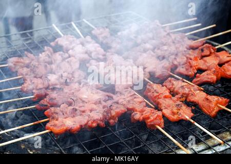 Chicken barbecue grilling  on smoky charcoal stove, Street food in Thailand Stock Photo