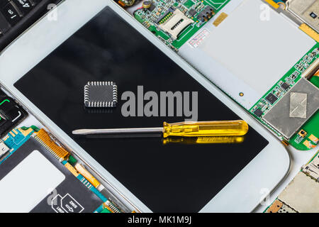 mobile phone with screwdriver on the background of electronic cards Stock Photo