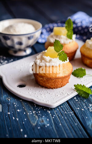 Coconut and pineapple muffins with yoghurt topping Stock Photo