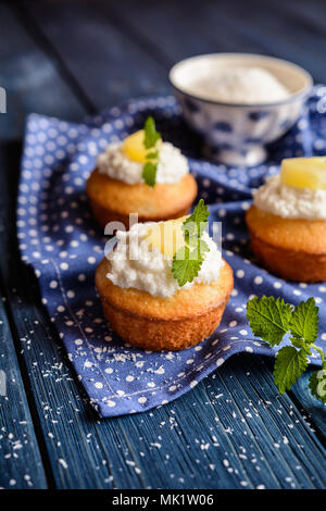 Coconut and pineapple muffins with yoghurt topping Stock Photo