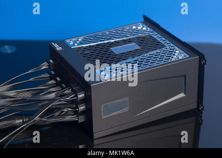 Computer Power Supply Unit on blue background Stock Photo