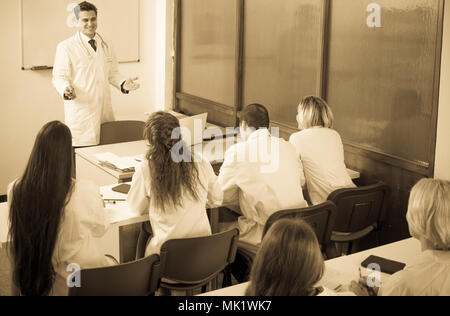 Multinational students and positive professor having discussion at medical faculty Stock Photo