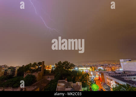 Intense stormy weather night with lightning bolts and thunderbolts against a dark cloudy sky.  Sudden seasonal weather changes often find city service Stock Photo