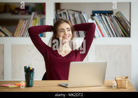 Satisfied female worker leaning in chair after finishing work Stock Photo