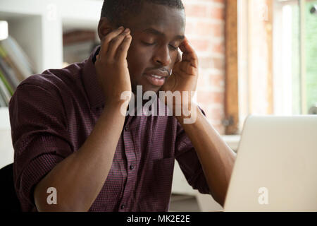 Thoughtful African American solving problem working at laptop Stock Photo