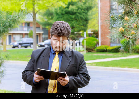 Businessman outside office Man buying online with a credit card and a tablet in the street Stock Photo
