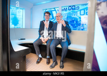 03 May 2018, Germany, Karlsruhe: Alexander Pischon (L), CEO of the Karslruhe transport federation, and Winfried Hermann (R) (Alliance 90/The Greens), Baden-Wuerttemberg's Minister of Transport, sit next to each other in the autonomous minibus e.Go Mover during the opening of the 'Testfelds Autonomes Fahren' (lit. test field autonomous driving). It is meant to sound the possibilities of driverless cars on selected tracks between Karlsruhe, Bruchsal and Heilbronn. Photo: Sebastian Gollnow/dpa Stock Photo