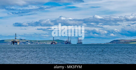 CROMARTY FIRTH SCOTLAND FOUR DECOMMISSIONED OIL RIGS  UNDERGOING REPAIR CROMARTY VILLAGE IN THE DISTANCE Stock Photo