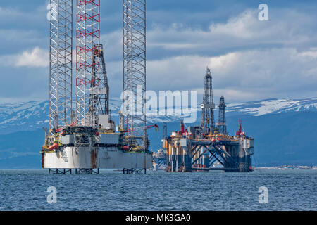 CROMARTY FIRTH SCOTLAND TALL OIL RIG OR DRILLING PLATFORM BAUG WITH DECOMMISSIONED OIL RIG AND SNOW COVERED HILLS
