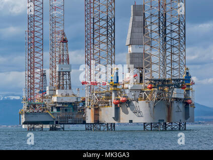 CROMARTY FIRTH SCOTLAND TALL STRUCTURED OIL RIG OR DRILLING PLATFORM BAUG LYING OFF CROMARTY VILLAGE WITH SNOW COVERED HILLS