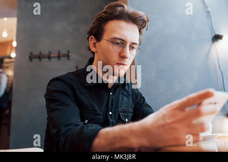 Close-up of man received good news on smart phone, Man resting in cafe and texting new mail messages, blurred background, shallow DOF Stock Photo