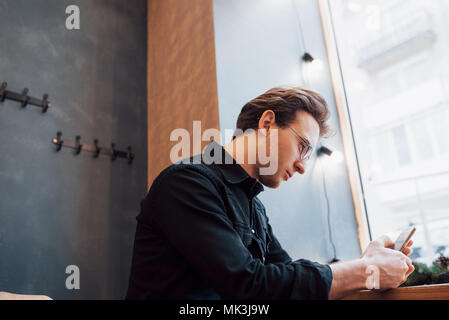 soft focus.man holding and using sell phone.while sitting and relax on sofa at modern house.concept for young people working mobile device Stock Photo