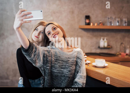 Two women friends sitting in cafe and make selfie Stock Photo