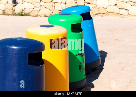 selective recicle bins with different colors in a mediterranean beach Stock Photo