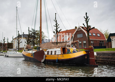 Family on boat in Holland, sailing in Amsterdam channels. Dutch family with kids on traditional residential yacht. Wooden ship in the Netherlands. Stock Photo