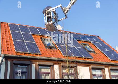 A german worker is mounting a photovoltaic system on a roof Stock Photo