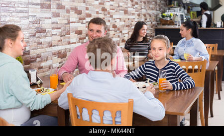 Glad family with teenagers having lunch in cozy cafe Stock Photo
