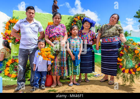 Santiago Sacatepequez, Guatemala - November 1, 2017: Indigenous family dressed in traditional clothing in cemetery on All Saints' Day. Stock Photo