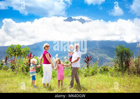 Grandparents and children hiking in mountains. Parents and kids trekking in Borneo jungle. Family looking at Mount Kinabalu peak, highest mountain of  Stock Photo