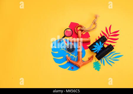 Summer vacation flat lay with beach accessories and tropical leaves on a vibrant yellow background. Travel essentials from above with copy space. Modern colorful palette. Stock Photo