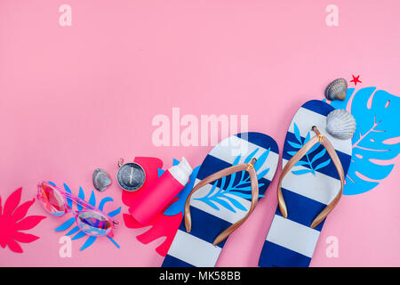 Beach accessories, flip flops, tropical leaves, seashells flat lay. Colorful travel and vacation concept on a bright pink background with copy space. Stock Photo