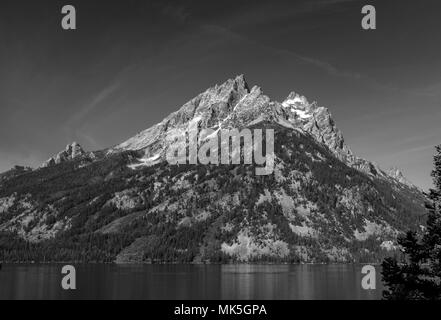 Majestic mountains peak with lake under sky. Black and white. Stock Photo