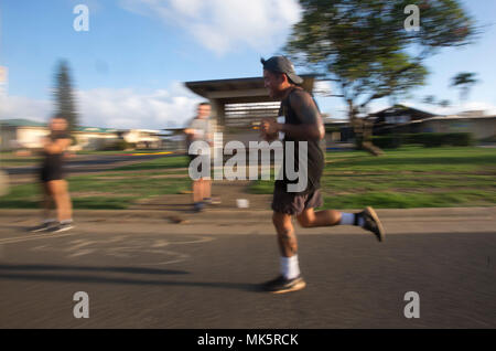 A contestant runs past a water checkpoint during the Turkey Trot 10k race, Marine Corps Base Hawaii, Nov. 4, 2017. The Turkey Trot, hosted by 3rd Radio Battalion and Marine Corps Community Services, is an annual Thanksgiving-themed event that is open to Marines, their families, and civilian participants. The event promotes readiness and resiliency across the installation and local community by encouraging healthy, family-oriented activity. (U.S. Marine Corps photo by Lance Cpl. Luke Kuennen) Stock Photo