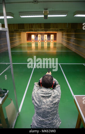 A U.S. Soldier with the 650th Military Intelligence Group fires at his target with an M9 pistol during qualification at the Training Support Center Benelux 25-meter indoor range, on Chièvres Air Base, Belgium, Nov. 09, 2017. (U.S. Army photo by Visual Information Specialist Pierre-Etienne Courtejoie) Stock Photo