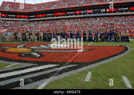 Military recruits walk off the field with their recruiters after reciting the oath of enlistment given by Marine Lt. Gen. Joseph Osterman, deputy commander of U.S. Special Operations Command, during the Tampa Bay Buccaneers Salute to Service game in Tampa, Fla., Nov. 15, 2017. The game provided the NFL and fans a forum to honor service members, veterans and their families. (Photo by U.S. Air Force Master Sgt. Barry Loo) Stock Photo