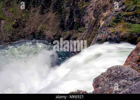 Water rushing over a cliff creating a waterfall that empty into the canyon below. Stock Photo