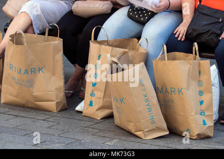 Primark 100% natural biodegradable brown paper women's fashion discount clothing store reusable shopping bags being carried by shoppers in Blackpool, UK Stock Photo