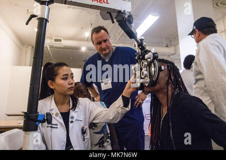 Army Reserve Capt. Gregory Empey, Optometrist, overseas Ia Ong Her, a 3rd year Optometry student, during Care Harbor, a free clinic, in Los Angles, Calif., on Nov. 18, 2017. Empey is overseeing students like Her as they provide vision assessments and prescriptions to hundreds of people in the Los Angeles area who would otherwise not have access to this type of medical care. Stock Photo