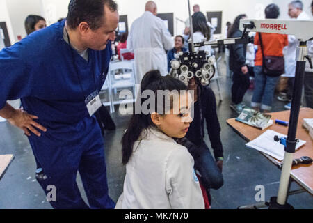 Army Reserve Capt. Gregory Empey, Optometrist, overseas Ia Ong Her, a 3rd year Optometry student, during Care Harbor, a free clinic, in Los Angles, Calif., on Nov. 18, 2017. Empey is overseeing students like Her as they provide vision assessments and prescriptions to hundreds of people in the Los Angeles are who would otherwise not have access to this type of medical care. Stock Photo