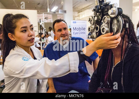 Army Reserve Capt. Gregory Empey, Optometrist, overseas Ia Ong Her, a 3rd year Optometry student, during Care Harbor, a free clinic, in Los Angles, Calif., on Nov. 18, 2017. Empey is overseeing students like Her as they provide vision assessments and prescriptions to hundreds of people in the Los Angeles area who would otherwise not have access to this type of medical care. Stock Photo