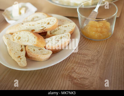 Crispy French Slice Bread, Butter and Pineapple Jam on Wooden Table for Breakfast in The Morning Stock Photo