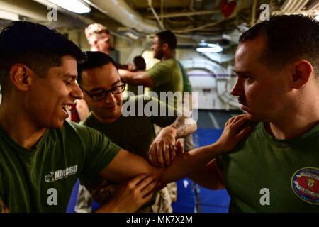 171113-N-BK384-122 MEDITERRANEAN SEA (Nov. 13, 2017) U.S. Marine Gunnery Sgt. Orlando Villalobos, middle, from Corpus Christi, Texas, shows Sailors the pressure points during a Marine Corps martial arts program aboard the San Antonio-class amphibious transport dock ship USS San Diego (LPD 22) Nov. 13, 2017. San Diego is deployed with the America Amphibious Ready Group and the 15th Marine Expeditionary Unit to support maritime security and theater security cooperation in efforts in the U.S. 6th Fleet area of operations. (U.S. Navy photo by Mass Communication Specialist 3rd Class Justin A. Schoe Stock Photo