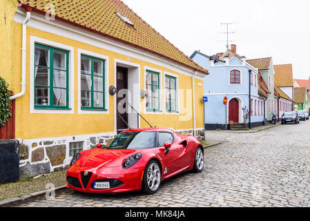 Simrishamn, Sweden - April 27, 2018: Travel documentary of everyday life and environment. Red 2016 Alfa Romeo 4c parked on cobblestone street outside  Stock Photo