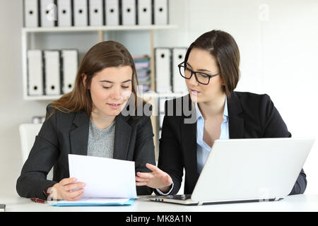 Two executives working together talking about documents at workplace Stock Photo