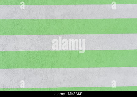 parallel strips of beige and green color on the plastered wall. Background Stock Photo
