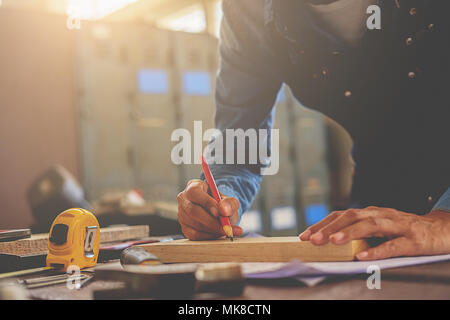 Carpenter working on woodworking machines in carpentry shop. woman works in a carpentry shop. Stock Photo