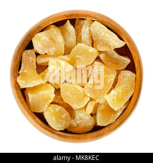 Candied ginger root chunks in wooden bowl. Crystallized roots of Zingiber officinale. Orange colored rhizomes, preserved with sugar. Snack. Stock Photo