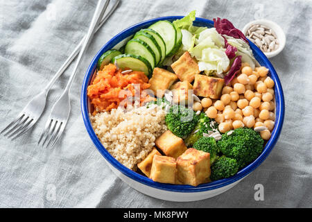 Nourishing buddha bowl with tofu, quinoa and vegetables. Healthy eating, healthy lifestyle, vegan food, vegetarian diet, modern lifestyle concept. Col Stock Photo
