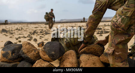 U.S. Army National Guard Spc. Keifer Davis, 3rd Battalion, 144th Infantry Regiment, Task Force Bayonet, stacks rocks as he sets up a defensive position on the first day of a French Desert Commando Course at the Djibouti Range Complex near Arta, Djibouti, Nov. 26, 2017. The 12-day course will expose service members to the fundamentals of desert combat, survival, and troop movements while also bridging language and cultural barriers between the French and American troops. (U.S. Air Force photo by Staff Sgt. Timothy Moore) Stock Photo