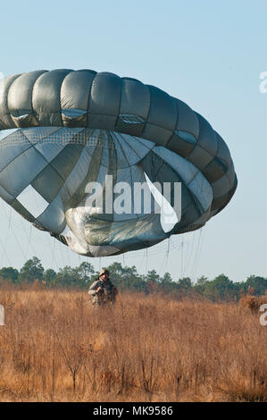 Chief Warrant Officer Mike Rich, a jumpmaster and the Command Chief Warrant Officer for U.S. Army Civil Affairs Psychological Operations Command (Airborne), stands up after jumping from a helicopter as part of the first jumpmaster validation exercise for Operation Toy Drop at Ft. Bragg, N.C., Nov. 30, 2017. Established in 1998 by a USACAPOC(A) Soldier, Operation Toy Drop draws thousands of Soldiers each year with the opportunity to participate in a collective training and airborne operation conducted by U.S. and foreign jumpmasters. Stock Photo